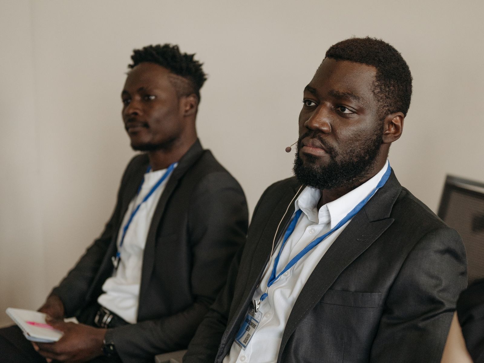 Two men attentively listening at a workshop session